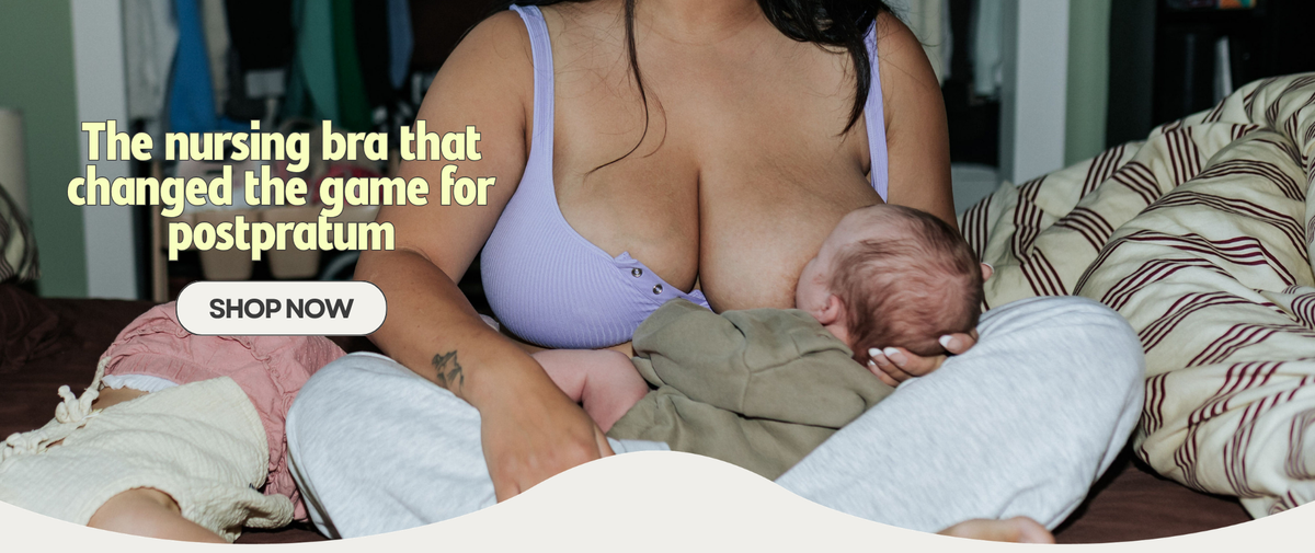 Mom nursing her newborn in the lilac Allie Bra while her toddler sits beside her